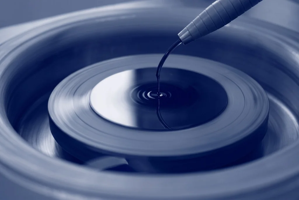 Photoresist being dispensed onto a rotating substrate during spin coating