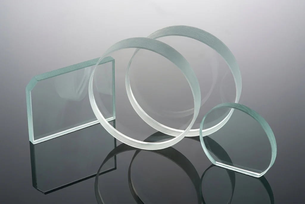Circular, rectangular and custom-shaped transparent optical windows arranged on a dark reflective surface